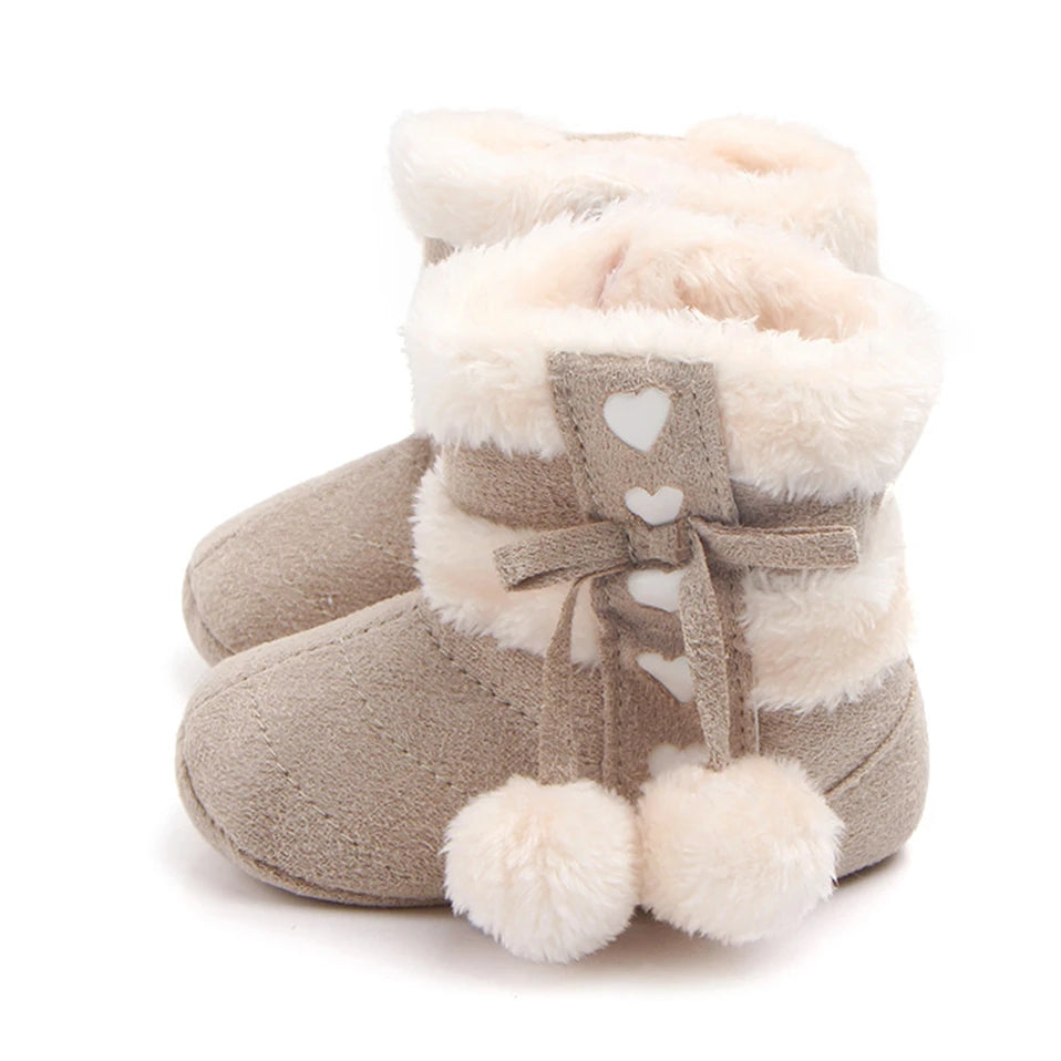 Adorable heart slipper boots for babies with plush lining and pom poms, perfect for winter warmth - fawn colour