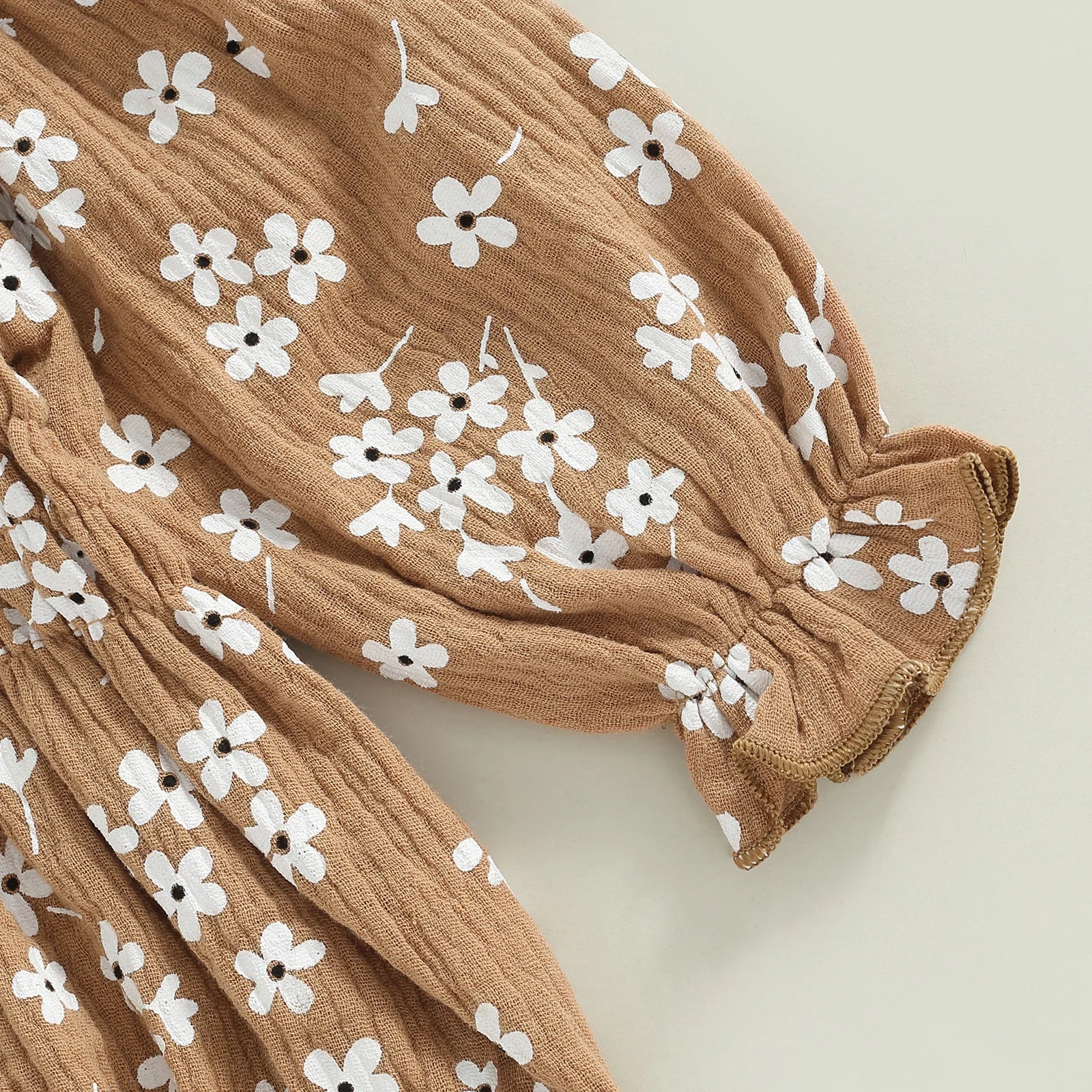 Close-up of floral print on tan Sadie Boho Romper for baby girl outfit, showcasing soft fabric and elegant puff sleeves.