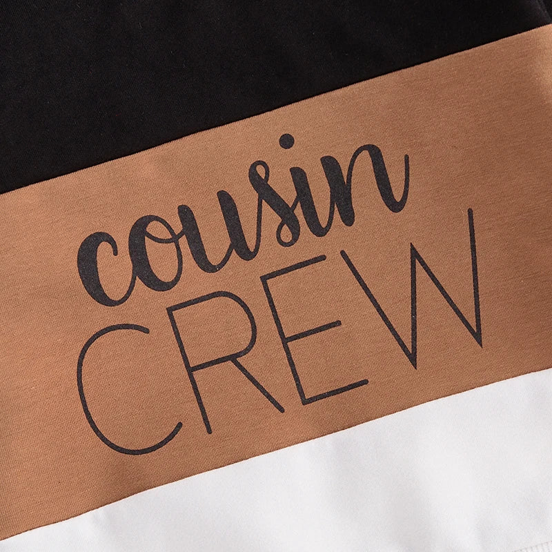 Close-up of the 'Cousin Crew' graphic on a stylish colour-block tracksuit for kids (brown).