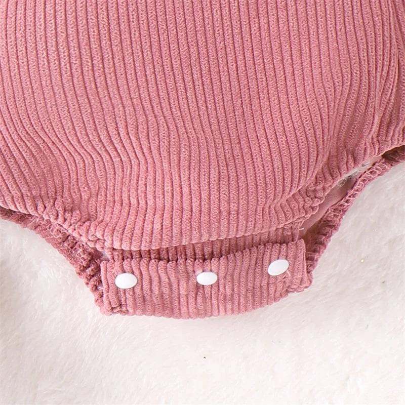 Close-up of dusty pink ribbed corduroy fabric and snap fastenings of the Pink Bunny Corduroy Romper for baby Easter outfit.
