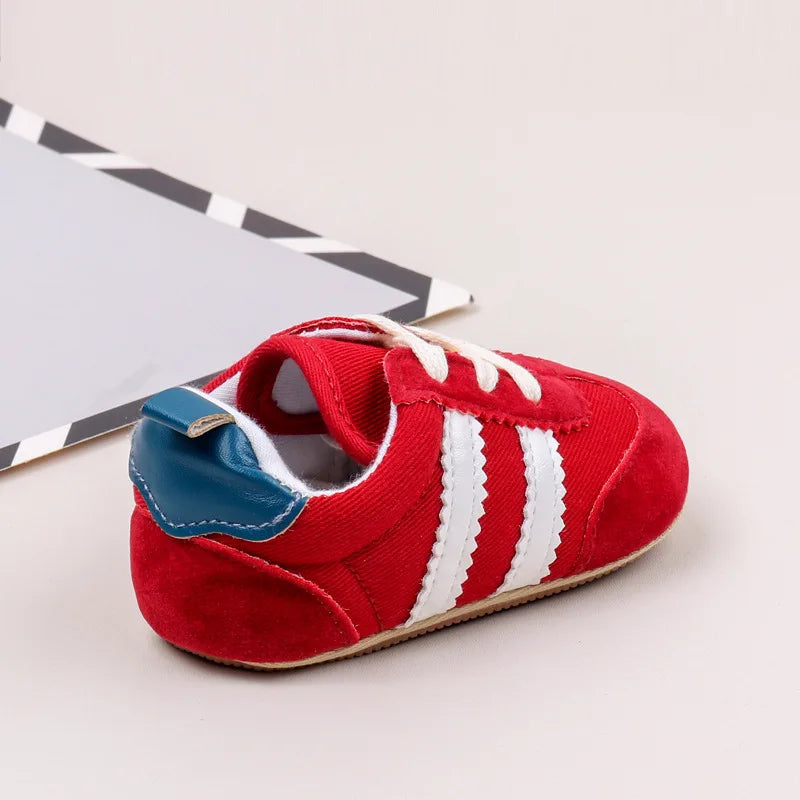 Classic stripe baby sneakers in vibrant red with white stripes, perfect for tiny feet aged 0-18 months.