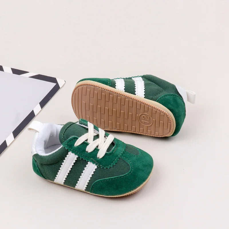 Classic stripe baby sneakers in vibrant green with white stripes for stylish little adventurers.