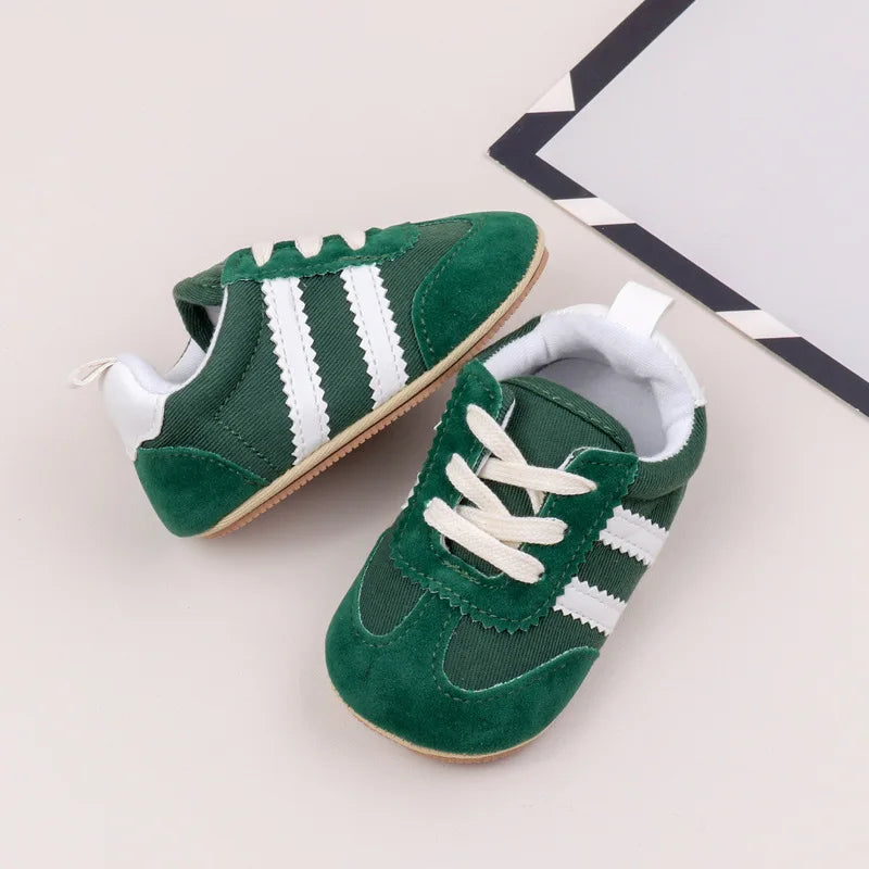 Classic stripe baby sneakers in green with white stripes for stylish little feet.
