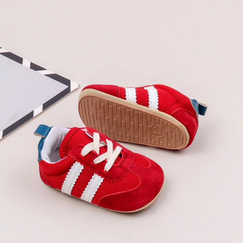 Classic stripe baby sneakers in red, ideal for stylish tiny feet aged 0-18 months.