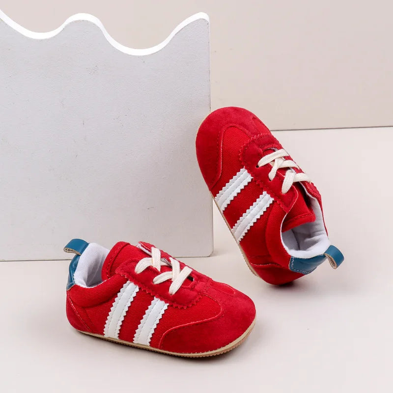 Classic stripe baby sneakers in vibrant red with white stripes, perfect for tiny feet aged 0-18 months.