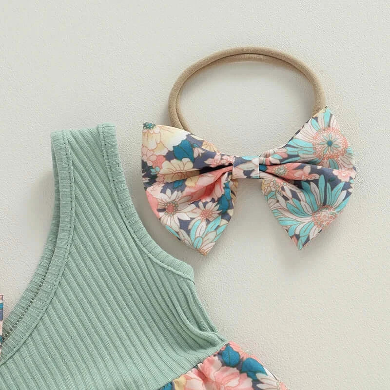 Close-up of baby girl summer outfit showing green ribbed fabric of romper bodice