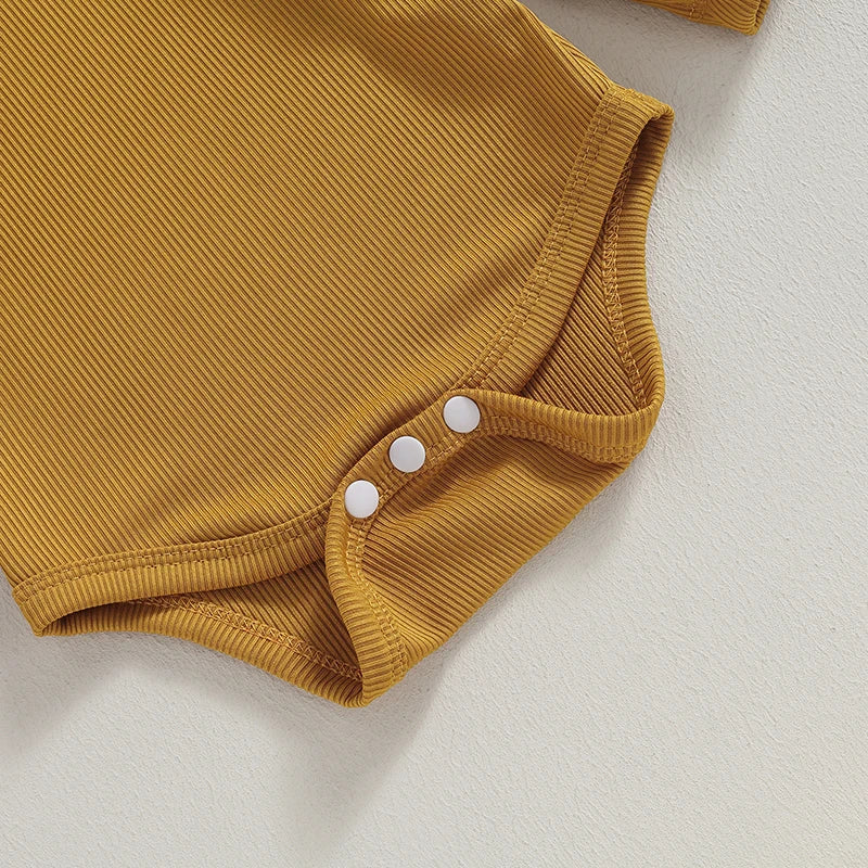 Close-up of mustard ribbed ruffle romper for baby girls with snap fasteners for easy changing.