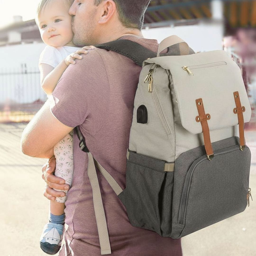 Dad wearing the Amalfi nappy backpack in white and grey, carrying a toddler