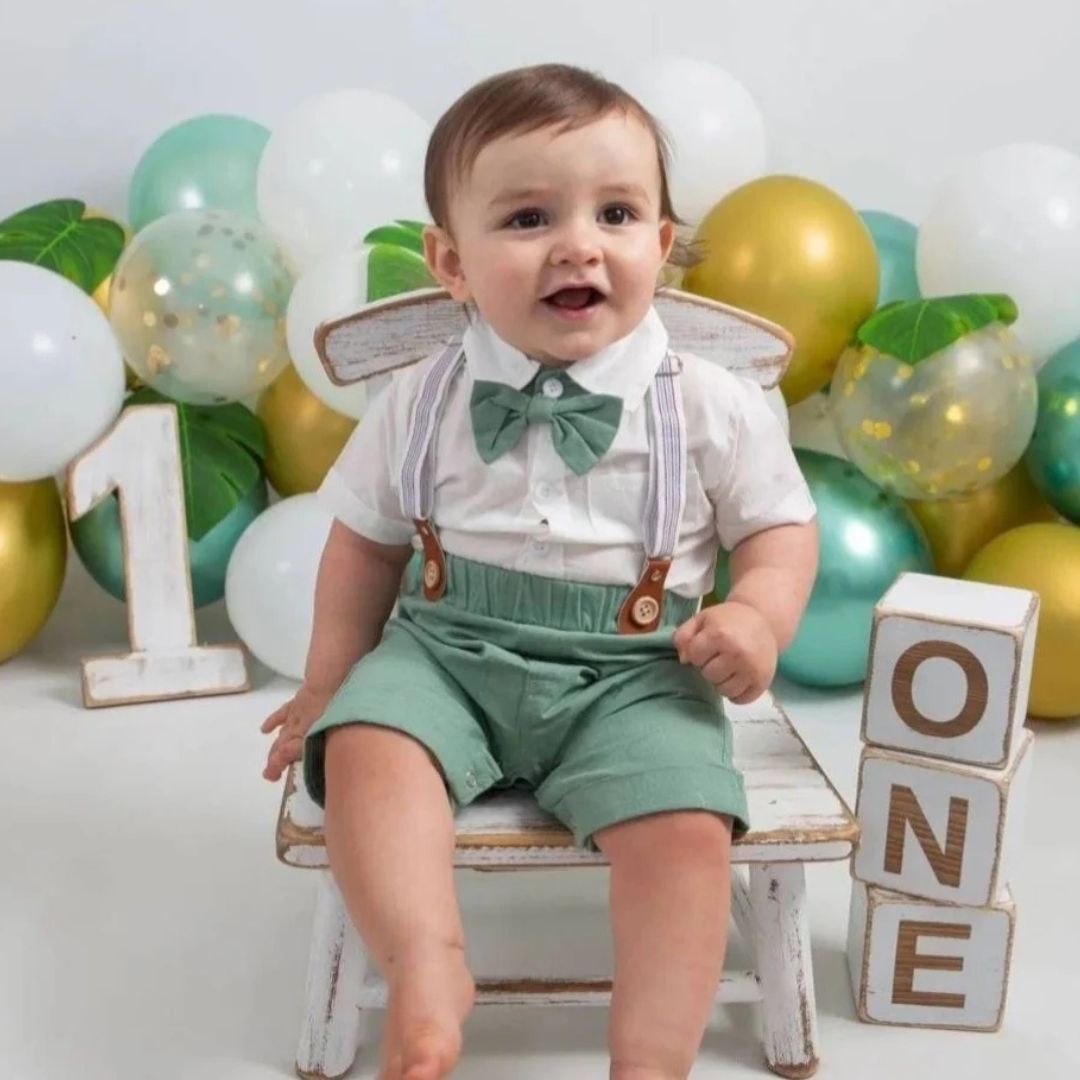 Baby boy wearing our gentleman suspender shorts and romper set in green
