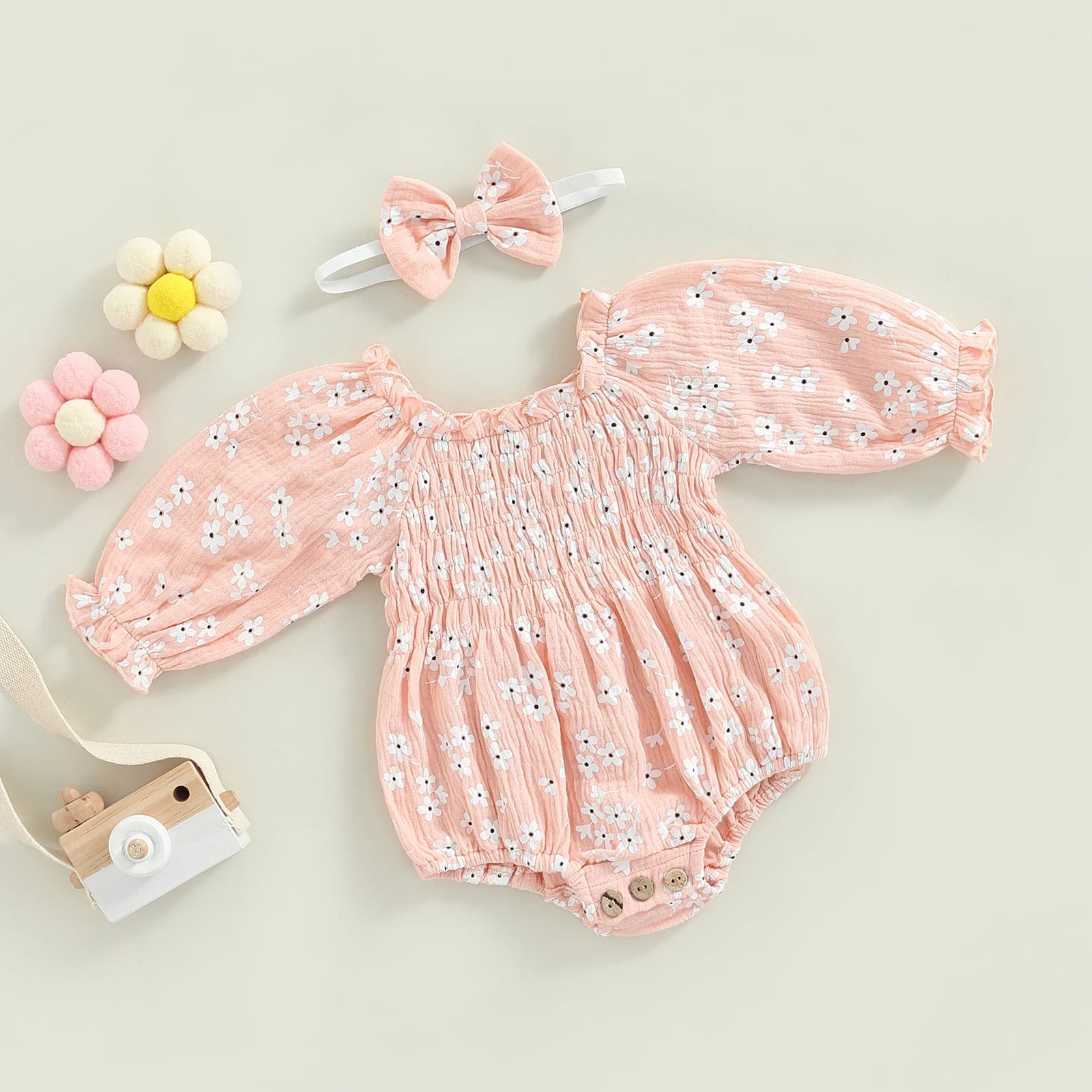 Floral Baby Girl Romper in pink with matching headband styled flat lay