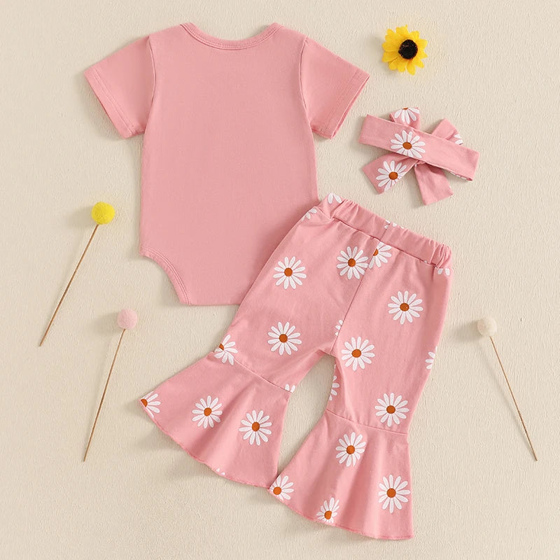 Back view of pink baby girl first birthday outfit styled flat lay