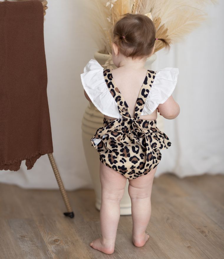 Baby girl wearing leopard pinafore romper showing backless design