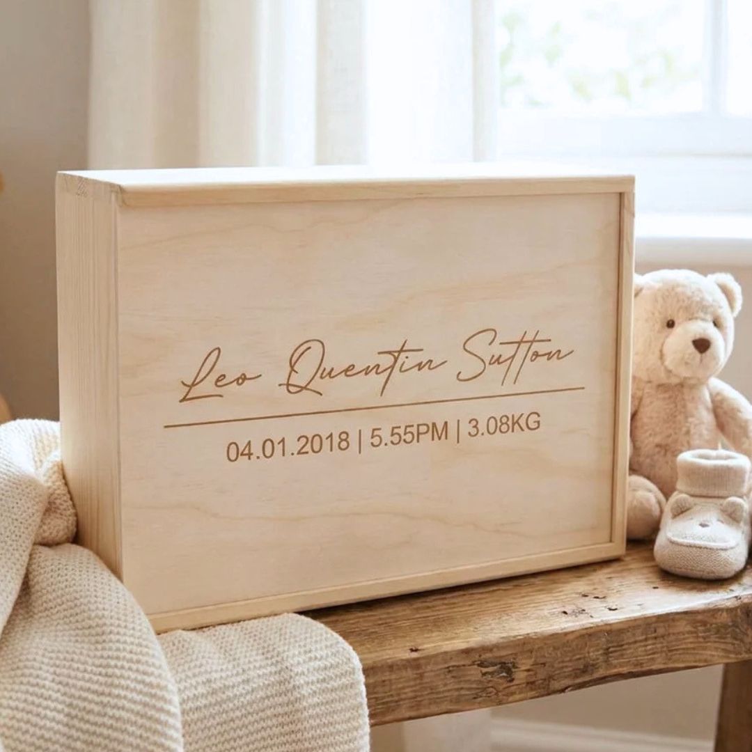 Wooden baby keepsake box engraved with name and birth details, displayed on shelf
