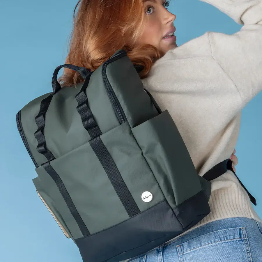 Mum wearing a stylish Babymel Finn nappy backpack in olive.