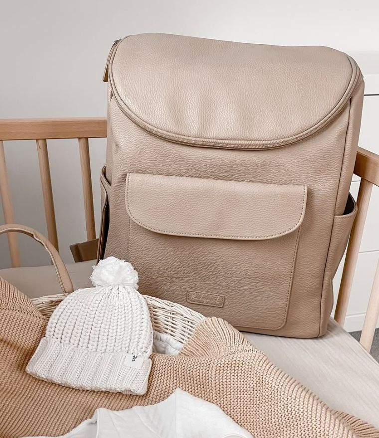 Babymel Lennox nappy backpack in oat, lifestyle image in baby nursery