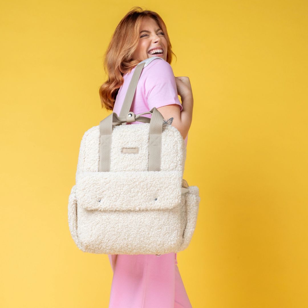 Mum wearing the Babymel Teddy Cream Nappy Backpack, showcasing its soft fleece design.