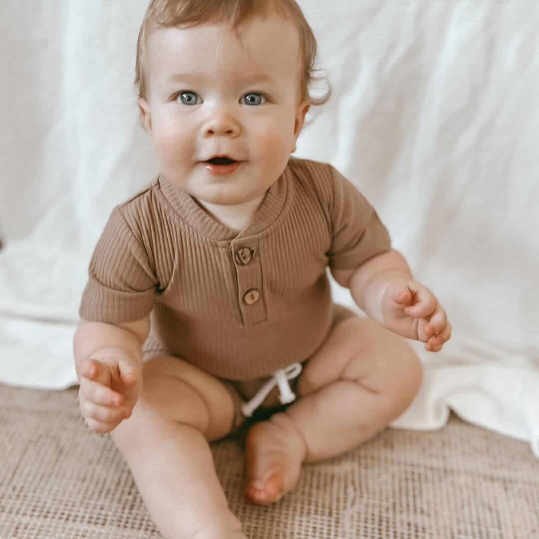 Baby boy wearing ribbed romper & shorts set from Lulu Babe - also comes in blue, mint green, mustard & grey