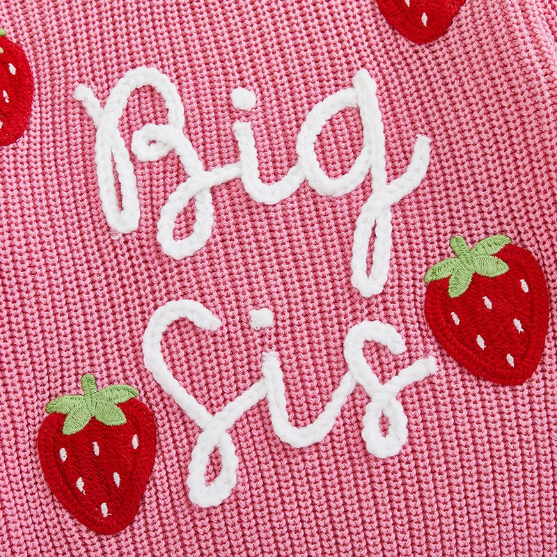 Closeup of big sister pink strawberry jumper showing "Big Sis" embroidery