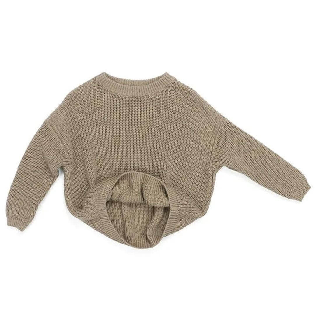Chunky knitted baby and toddler jumper in a soft taupe colour laid flat on a white background.