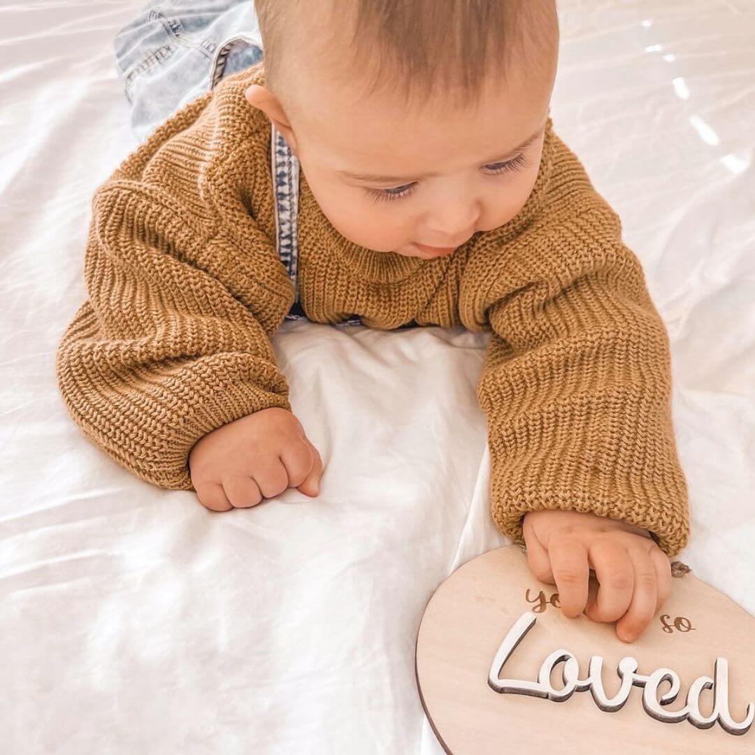Baby boy wearing knitted jumper in mustard