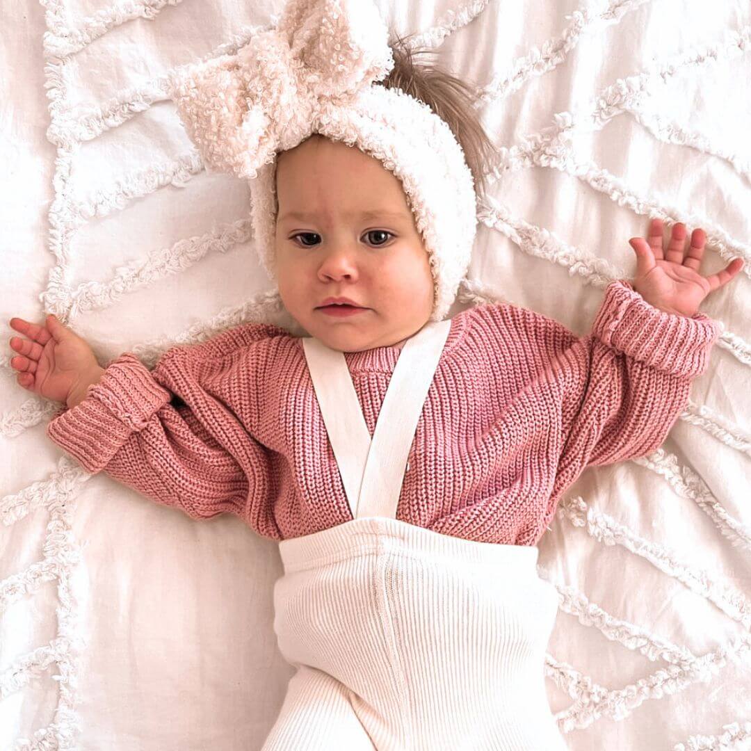 Baby girl wearing rose knitted jumper with suspender tights