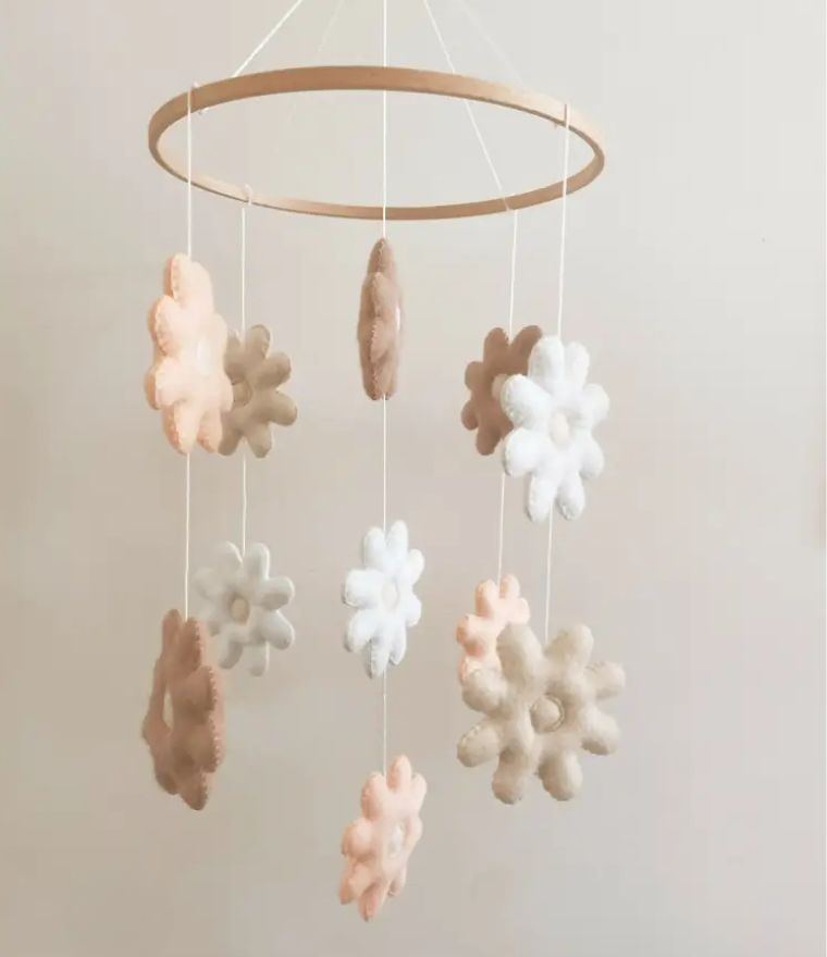 Daisy baby cot mobile with felt flowers in soft cream, pink, and brown tones for a charming nursery mobile.