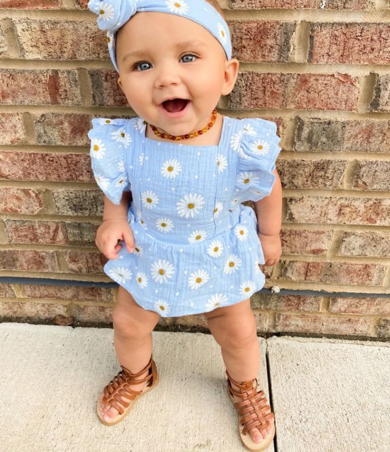 Baby girl modelling our Daisy Ruffle Romper in blue