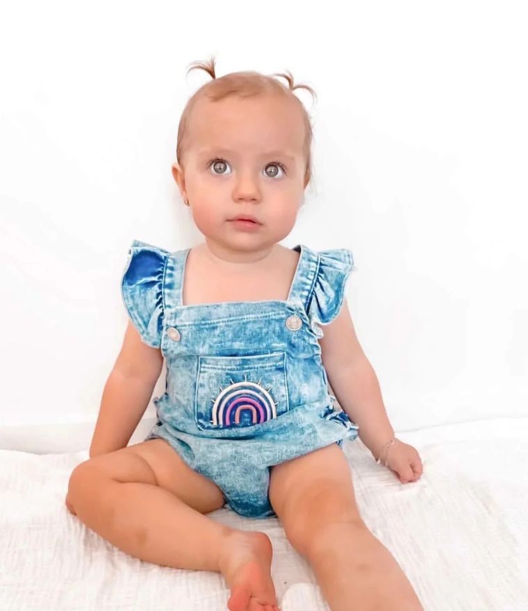 Baby girl sitting, wearing Denim Ruffle Rainbow Romper - Lulu Babe