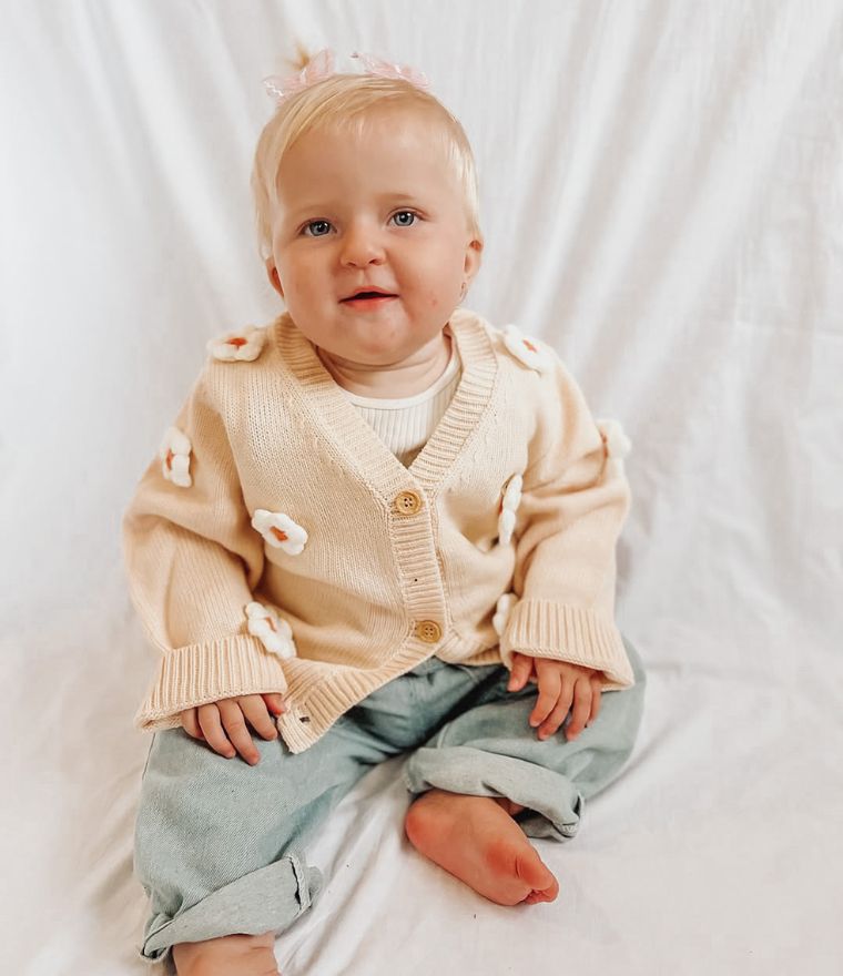 Baby girl wearing daisy bloom cardigan in beige
