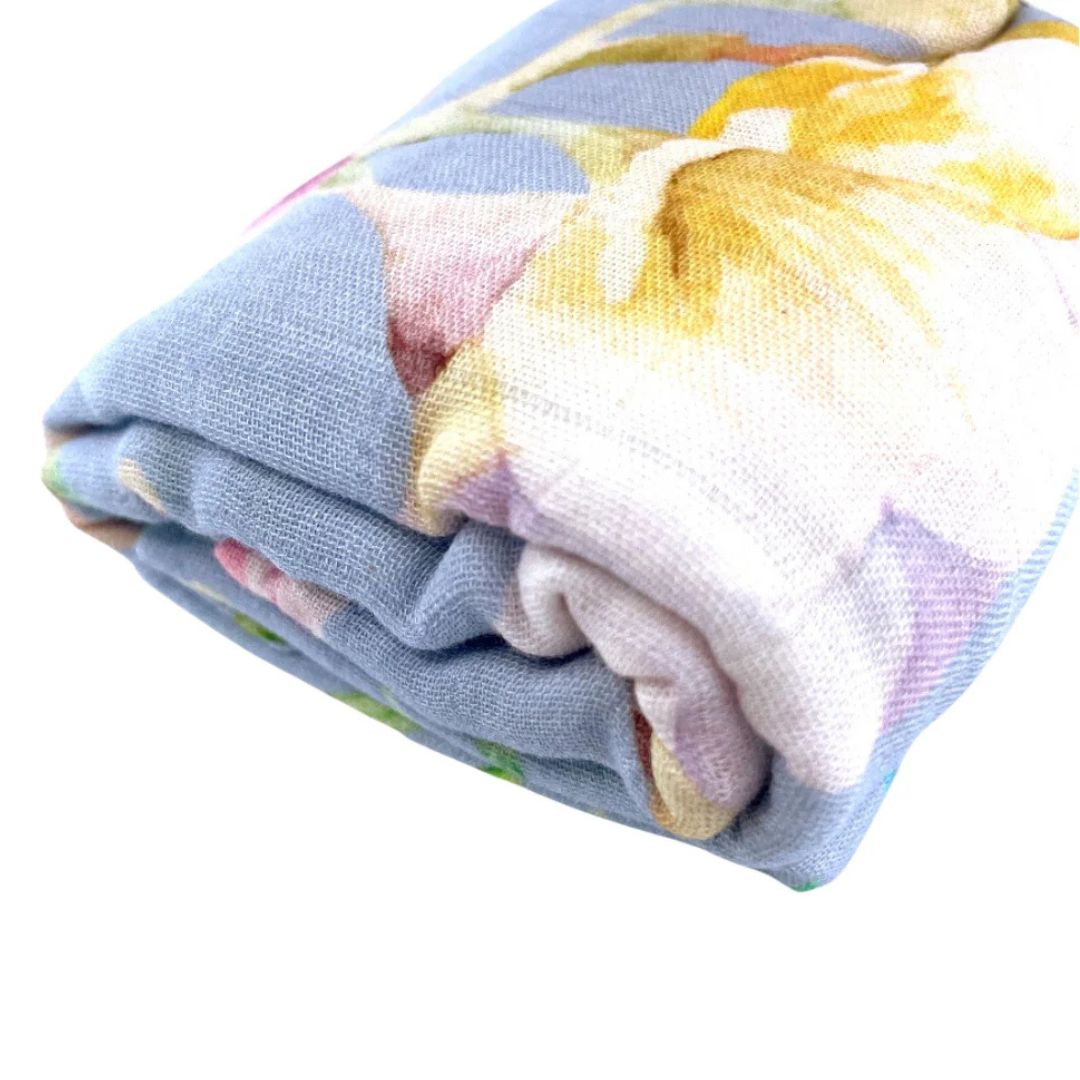 Floral Muslin Wrap folded with vibrant floral prints on a soft, breathable fabric, perfect for swaddling and nursing.