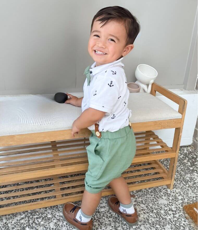 Toddler boy wearing our gentleman suspender shorts set in green