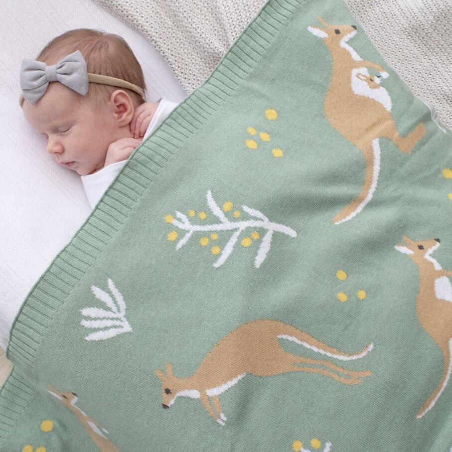 Baby sleeping under green kangaroo baby blanket