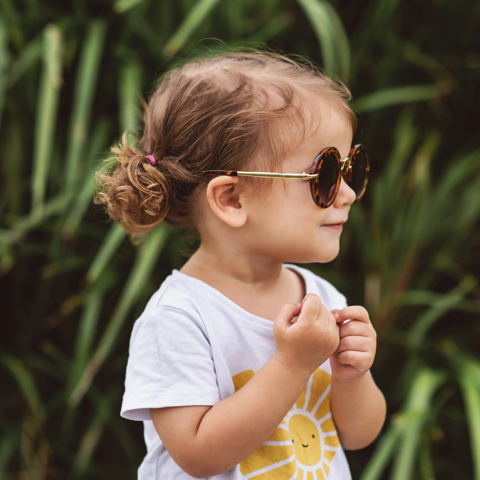 Girl wearing round retro kids sunglasses with UV400 lenses