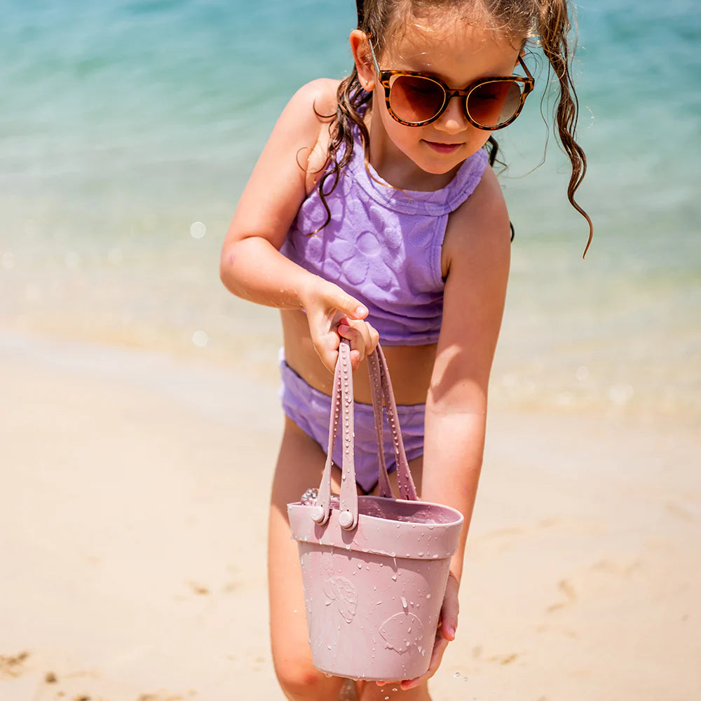 Girl wearing oversized cat-eye sunglasses in leopard print at the beach