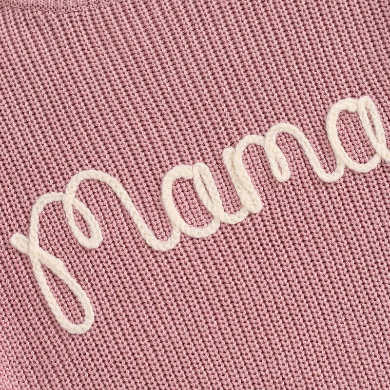 Closeup of mama knit jumper in rose pink showing embroiery