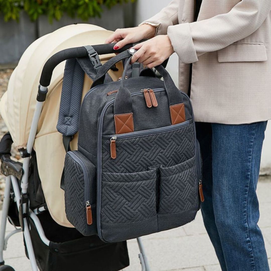Urban nappy backpack in charcoal attached to pram with built-in straps