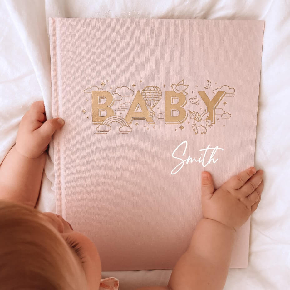 Baby's hands grabbing personalised keepsake journal in rose, for recording milestones and memories