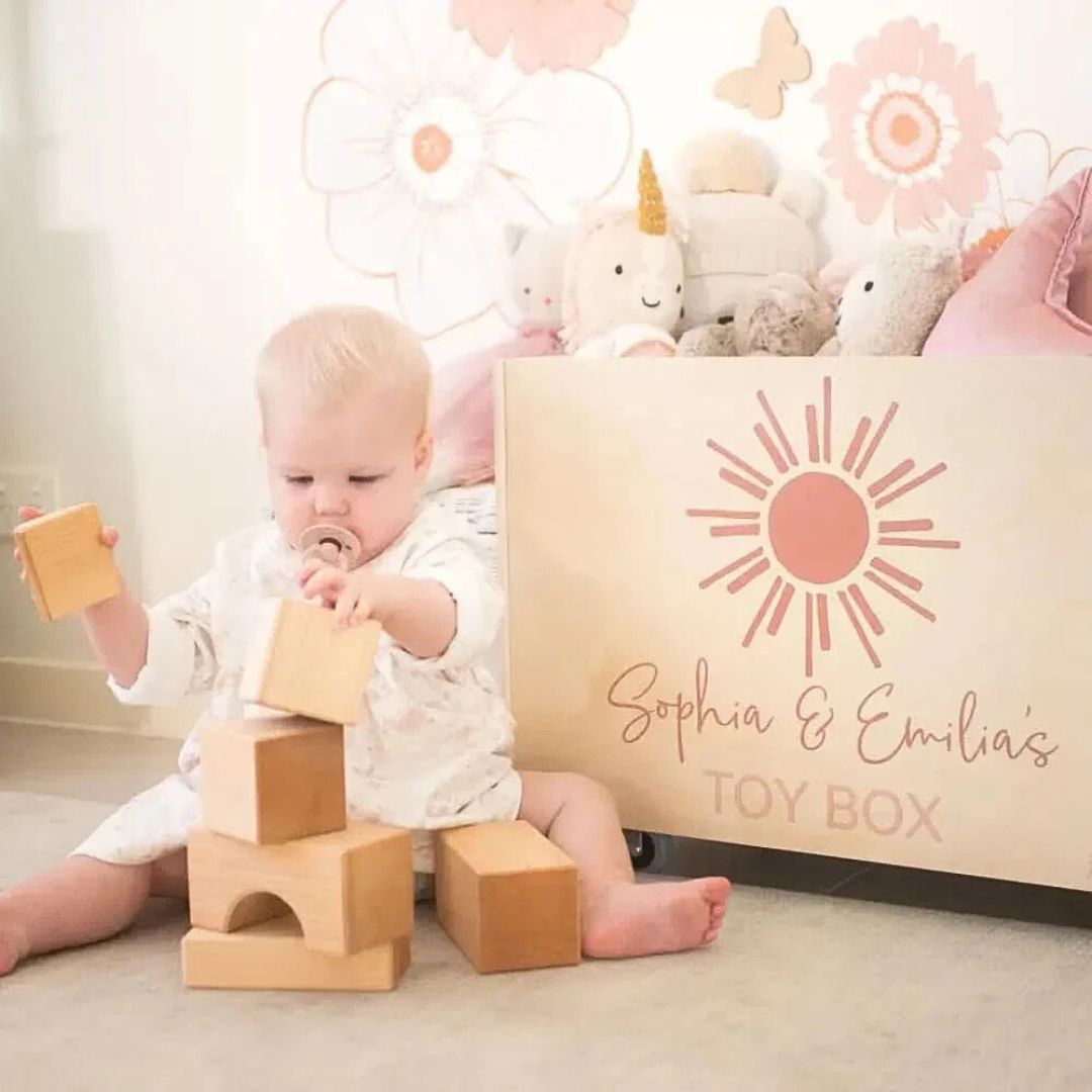 Child playing with wooden blocks next to a Personalised Wooden Toy Box