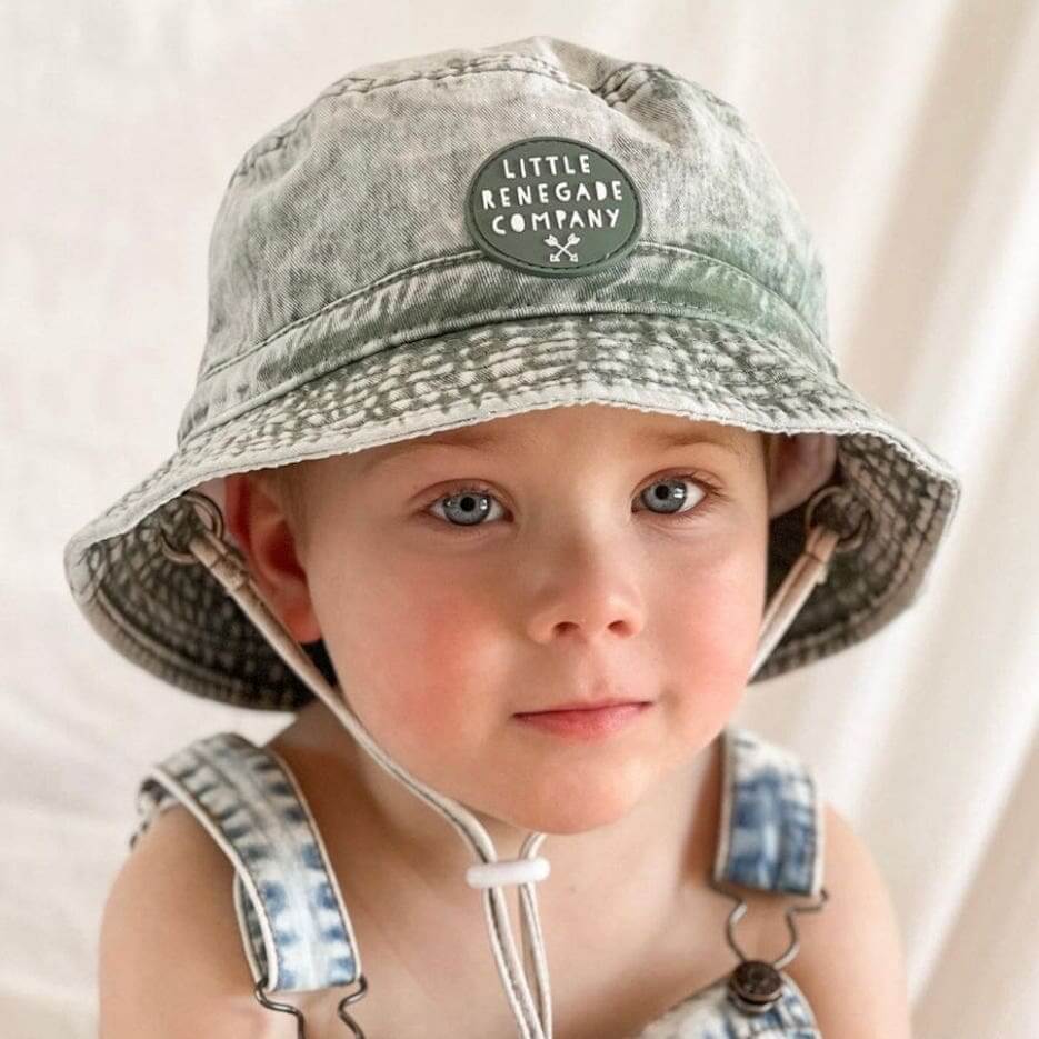 Child wearing green denim bucket hat by Little Renegade Company