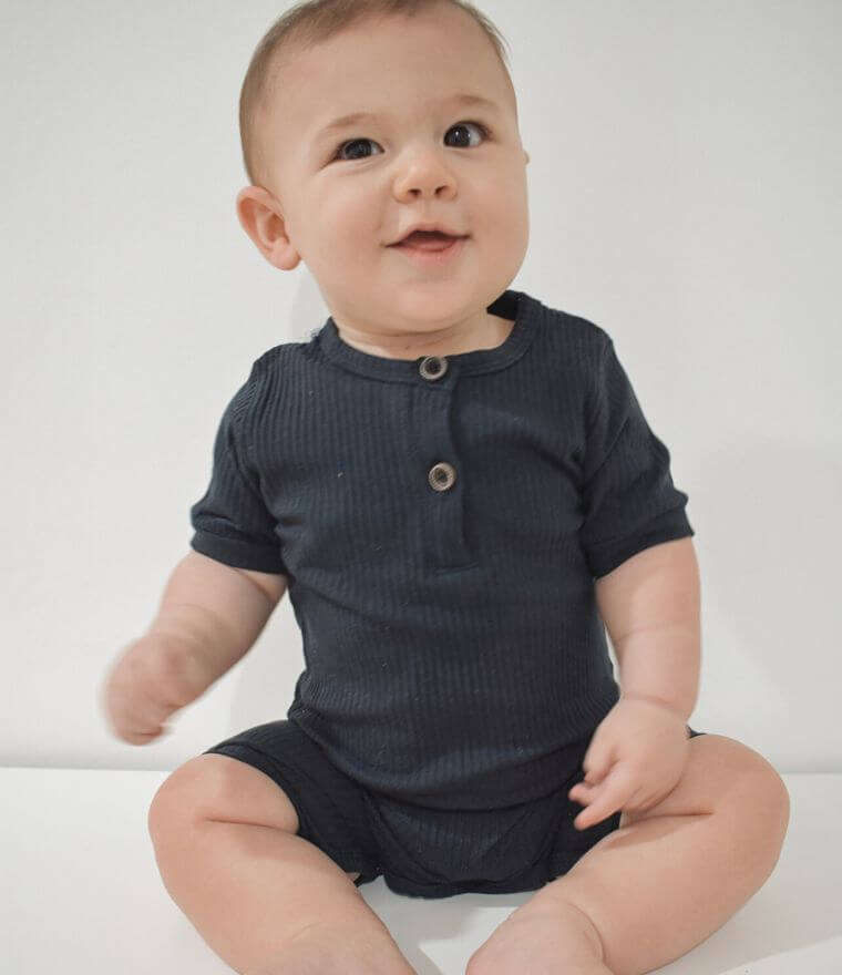 Baby boy wearing short sleeve ribbed romper in navy