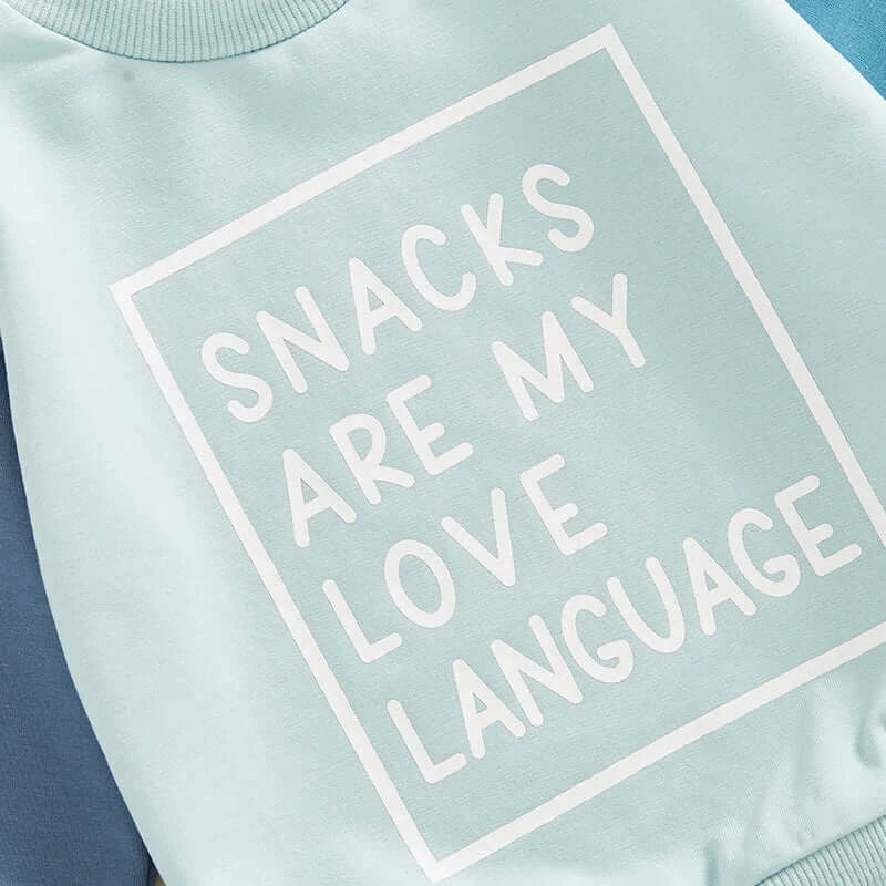 Close-up of "Snacks Are My Love Language" baby tracksuit set in blue