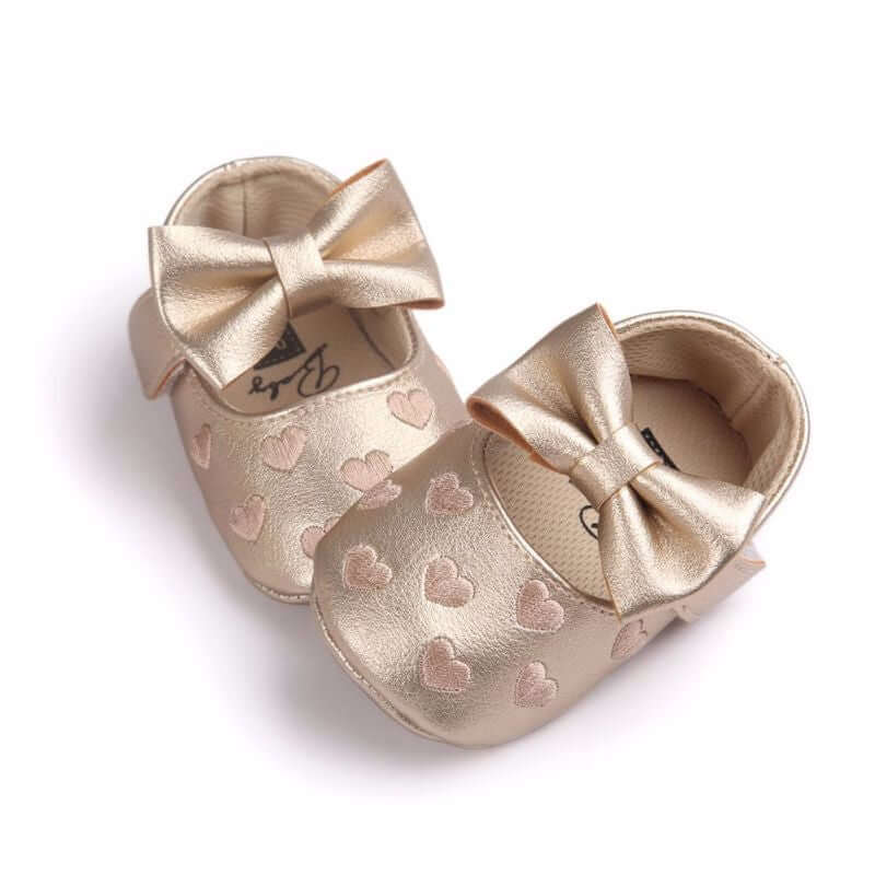 Gold baby girl moccasins with embossed hearts and bows