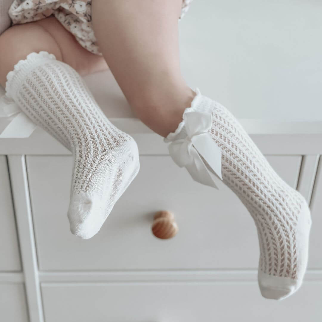 Lifestyle image of baby girl lace knee high socks in white