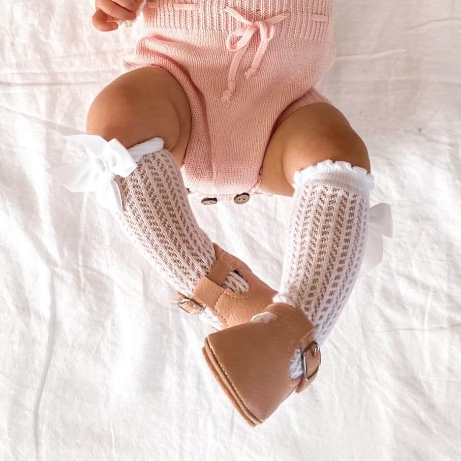Baby girl wearing white lace knee high socks