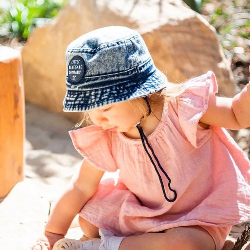 Toddler wearing blue denim bucket hat by Little Renegade Company