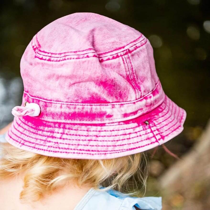 Toddler wearing pink denim bucket hat by Little Renegade Company