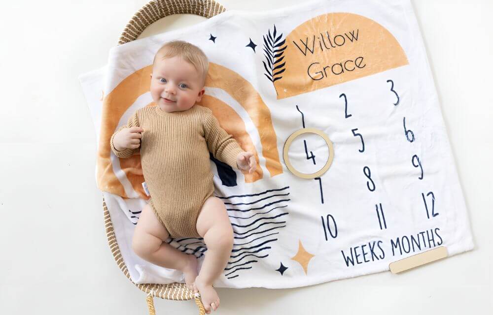 Baby memory ideas - baby lying on a personalised milestone blanket