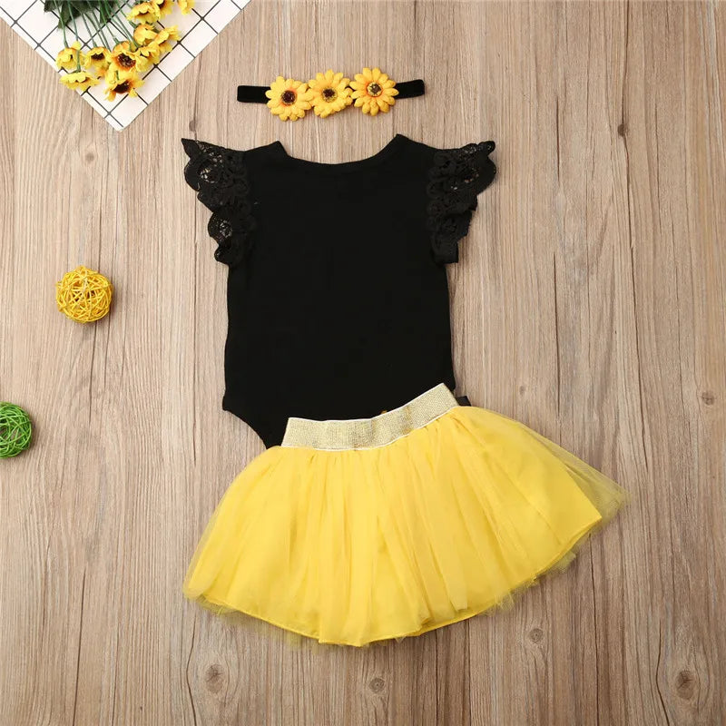 Baby girl first birthday outfit with black "One" bodysuit, yellow tutu skirt and sunflower headband
