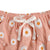 Close-up of the soft pink fabric featuring cheerful daisy print and tie detail, part of the Daisy Ruffle Peplum Set.