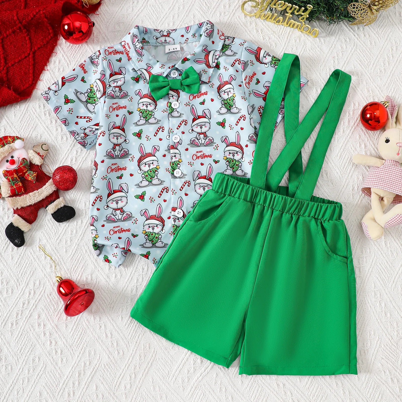 Baby boy Christmas outfit with green suspender shorts and playful bunny print shirt for festive occasions.